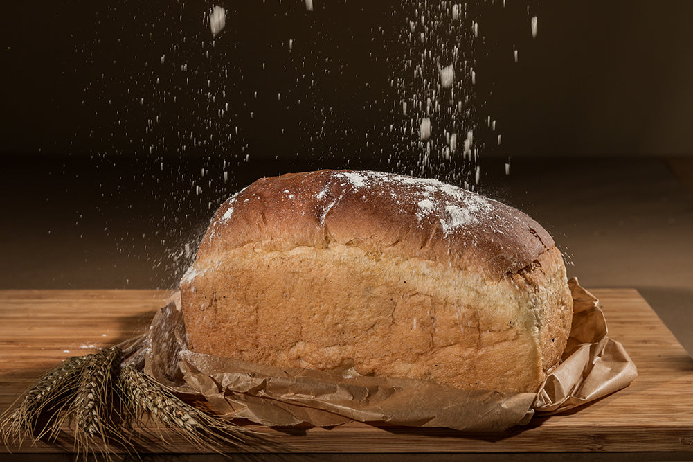 Flour falling over a freshly baked white loaf