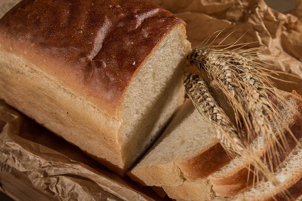 Golden tin loaf, sliced on a wooden board