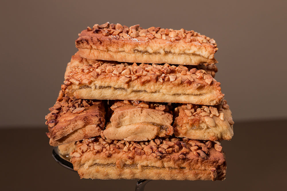 Sandwich biscuits stacked, peanut crumbs scattered